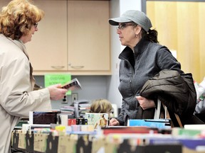 Brenda Jay, left, and Maria Da Silva discuss some of their finds at the Chatham-Kent Public Library Flood Relief book sale at the main branch Thursday. The sale runs during library hours until Saturday with all proceeds being used to replace books damaged in the flood in early December 2012. PHOTO TAKEN :  Chatham, On., Thursday February 28 2012. DIANA MARTIN/ THE CHATHAM DAILY NEWS/ QMI AGENCY