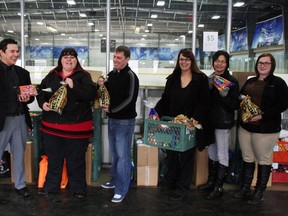 Ringing in the new era of the Mobile Pantry Program at the Fort McKay Community Arena Thursday, left to right, Phillip Fitzpatrick, with the Hyde Hockey Tournament, Arianna Johnson, executive director of the Wood Buffalo Food Bank, Dan Edwards, client services manager with the WBFB, and Lisa Grandjambe, social assistance worker with the Fort McKay health centre, gathered to announce the launch of the program that’s been in the works for close to a year. AMANDA RICHARDSON/TODAY STAFF