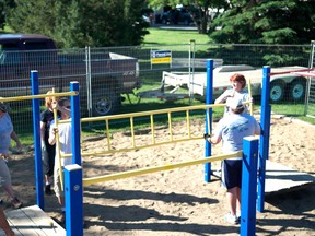 Volunteers dismantle old playground equipment in Spruce Grove to prepare it for shipment halfway around the world. Submitted photo.