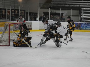 Grande Prairie Kings forward Nolan Trudeau whips a shot past Fort St. John Huskies goalie Travis MacLean, with Kings forward Daniel Bishop (wearing "A") and Huskies captain Shawn Holliday creating havoc in front. The goal tied the game 2-2 in the second period of Game 1 of the North West Junior Hockey League semifinal series. The Huskies replied with a pair of goals in the next four minutes and skated to a 6-3 victory. Terry Farrell/DHT staff/QMI Agency