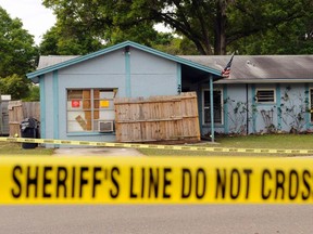 Police tape surrounds a home where a sinkhole opened up and swallowed a man in Seffner, Florida on March 1, 2013. (REUTERS/Brian Blanco)