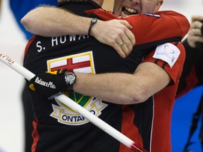 Glenn and Scott Howard hug during the 20122 Brier in Saskatoon. (Reuters)