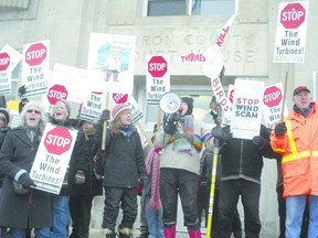 Protestors stand atop the stairs in front of the Huron County courthouse to show their opposition to a proposed 140-turbine wind farm in Huron County. (Paul Cluff, QMI Agency)