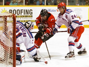 Rangers defenceman Ryan Murphy tries to hold back Owen Sound Attack forward Gemel Smith as he tries to bury a bouncing puck in front of Kitchener Rangers goalie Joel Vienneau in the opening moments of the first period during their OHL match up Friday, March 01, 2013 at the Lumley Bayshore in Owen Sound.