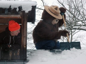Catfish Creek Conservation Authority supervisor Ed Pietrzak watches as Smokey the bear clears off the Sugar Shanty roof Thursday at Springwater Conservation Area. Their annual Maple Syrup Festival kicks off this weekend and continues weekends and through March Break until the end of the month.