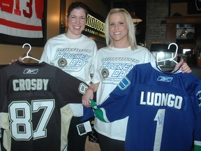Lindsay Disbrowe and Nicole Geerlinks with signed Sidney Crosby and Roberto Luongo jerseys, two prizes up for grabs during the Midtown Tavern's Hockey Day Saturday. Disbrowe and Geerlinks were the lead organizers in the event which was a joint fundraiser for ALS (Lou Gehrig's Disease) and Alzheimer's disease. NICK LYPACZEWSKI/ TIMES-JOURNAL/ QMI AGENCY