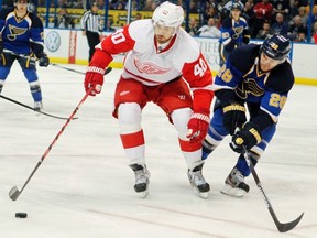 Red Wings forward Henrik Zetterberg (left) keeps the puck away from Blue defenceman Carlo Colaiacovo. Under a propossed realignment plan, the Red Wings will move from the Western Conference to the East. (Reuters/Files)