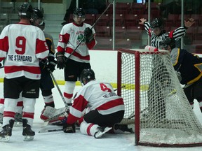 Kenora defender, Trevor Socholotuk, helps Ryan Landon keep the puck out of the net as the referee signals no goal. The Kenora Senior Thistles defeated the Manitoba Viper 4-3 on Saturday, Mar. 2.