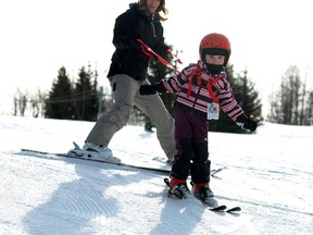 Jennifer Larson uses a harness to help her daughter Chloe down the run at Nitehawk Recreation Area, just south of Grande Prairieo n Sunday. Chloe, who turned 4 on Saturday, was on skis for just the second time in her life. TERRY FARRELL/DAILY HERALD-TRIBUNE