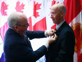 Canada's Parliamentary Budget Officer Kevin Page, right, receives the Queen Elizabeth II Diamond Jubilee medal from Senator Colin Kenny in Ottawa in this November 19, 2012 file photo. (REUTERS/Blair Gable)