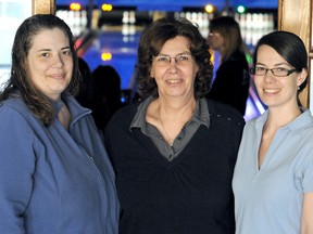 Loel Cross, centre, watched her daughters Janet Couvillon, left, and Sara Shore play in the Big Brothers Big Sisters of Chatham-Kent fundraising tournament Sunday at Bowlerama in memory of their father, Warren Cross. (MARK MALONE/The Daily News)