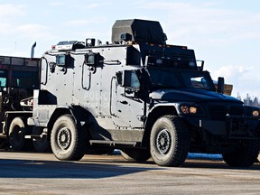 An armoured vehicle leaves through a roadblock after two suspects opened fire on a sheriff at the Whitecourt court house in Whitecourt, Alta., on Tuesday, Feb. 26, 2013. The suspects were apprehended shortly after fleeing.