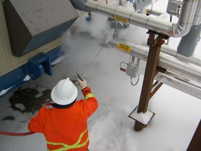 A worker with Devon Energy wears a prototype protective garment while working near steam at a well pad. SUPPLIED PHOTO