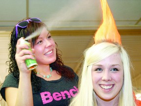 Kaye-Loni Curran sprays a little more colour onto her sister Taylor's flame-like hairdo during the Mohawks for Meningitis fundraiser at the Shakespeare Optimist Hall Sunday night in memory of Kasey Pestell. (MIKE BEITZ, The Beacon Herald)