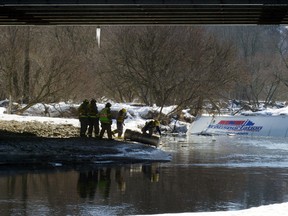 Firefighters at the scene of tractor-trailer crash under the Nith River bridge. The tractor-trailer plunged off Highway 401 in the eastbound lanes just west of Trussler Road between Woodstock, Ont., and Cambridge, Ont., on Tuesday, March 5, 2013.
