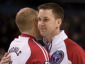 Brad Gushue and Mark Nichols hug following a match at the 2011 Brier in London, Ont. (QMI Agency)