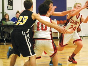 Saints’ Jarrod Sundmark tries to control a pass from teammate Ryan Landon while being chased by a Muskies’ player. St. Thomas Aquinas lost 52-50 to Fort Frances in overtime.
GRACE PROTOPAPAS/Daily Miner and News