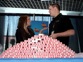 Kelsey Collins (left) and Travis McInnes dealers at OLG Casino Thousands Islands in Gananoque wait behind a large stack of playing cards to speak with  summer job seekers at the Student Summer Job Expo at the K-Rock Centre on Tuesday. (Ian MacAlpine The Whig-Standard)