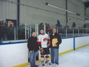 Alex Trotter of the midget Tier I Lightning receives his graduating certificate and gift from AMHA president Tim Kehoe (left) while at right