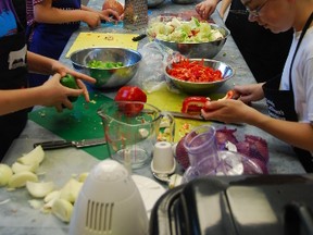 Grade 7 students at St. John Fisher School in Forest prepare a meal for their families at the end of a 10-week Food Works program. The healthy eating initiative, delivered by partners One Tomato and Lambton-Kent Agriculture in the Classroom, is looking for donations to meet growing demand for the program. (Submitted photo)