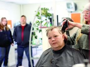 Laurie-Ann Grant watches in the mirror as the last of her hair is shaved by hairdresser Michelle Armer. Daughter Gracie and husband Shawn watch on. Grant is hoping her experiences are going to raise awareness about cancer and cancer resources in the community.