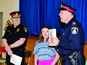 Vanier Public School Grade 6 student Lauren Armstrong reacts to receiving a new iPad2 from Sgt. Doug Locke, right, and police chief John Gardiner after her name for the new police dog, Chaser, was announced in an assembly on Wednesday. (DARCY CHEEK/The Recorder and Times)