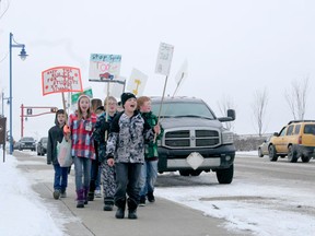 Grade 5/6 students from Eldorado Elementary School wave signs and chant during an early morning protest to remind motorists to slow down in the school zone.
