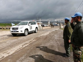 India's United Nations peacekeepers salute as a U.N. vehicle crosses from Syria into Israel at the Kuneitra border crossing on the Golan Heights March 5, 2013. (REUTERS/Baz Ratner)