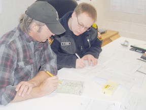 Pictured: Todd Lynch (left, Peace River Wildfire Prevention Officer with Government of Alberta) and Peter Wiebe (Town of La Crete fire department) work together inside the command post to determine the resources needed to protect residents and put out the fire on Thursday March 7, 2013 in Peace River