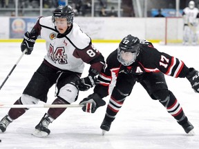 Chatham Maroons' Brennan Feasey, left, tries to get around Lambton Shores Predators' Tanner Ferguson in the first period Thursday at Memorial Arena. (MARK MALONE/The Daily News)