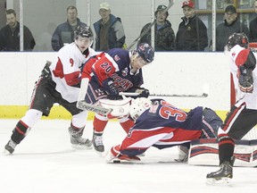Icemen goaltender Chris Sharkey pounces on the puck while defenceman Keaton White holds off an attacker during a game against the Fort Sask Hawks at the Civic Centre Feb. 27.