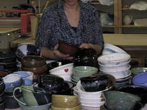 Devon Pottery Guild Secretary, Carmen Mitchell, organizes bowls handcrafted by herself, and other guild members Jan Dear, Sally Fairhead, Sylvia Kizior, Theresa Wilson and Gail Coleman in preparation for the 99 Bowls Event this week at the ECO Cafe in Pigeon Lake.