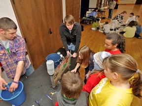 Lake Superior State University students Zach Bishop, left, and John Ransom demonstrate water table mechanics to group of Sault school children, while in the background LSSU geology professor Matthew Spencer helps students pan for gold during the 2012 St. Mary's River Environmental Summit. Area schoolchildren will be in LSSU's Cisler Center for this year's summit on March 16, 10:30 a.m.-3 p.m. The Binational Public Advisory Council (BPAC) for the St. Mary's River Area of Concern sponsors the event, which includes panel discussions on the history, culture, recreational opportunities, and ecology of the river and updates on efforts to restore environmental quality. For more information about BPAC, visit www.lssu.edu/bpac or e-mail stmarysriver@lssu.edu.