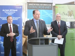 Nipissing-Timiskaming MP Jay Aspin and Jack Garland Airport manager Jack Santerre listen while Mayor Al McDonald speaks Friday during a news conference at the airport. Aspin announced more than $218,000 in funding for infrastructure at the facility.