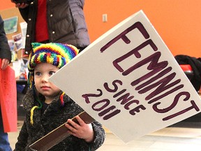 Nineteen-month-old Penelope Knowles lets her politics be known during a rally to mark International Women's Day Friday at noon inside the athletics centre at Queen's University.
Michael Lea The Whig-Standard