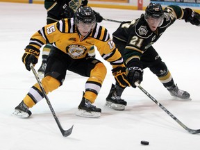 Sarnia Sting forward Davis Brown, left, and London Knights defenceman Tyler Ferry fight for a loose puck during the first period of their OHL game Friday night at the RBC Centre in Sarnia. (PAUL OWEN QMI Agency)