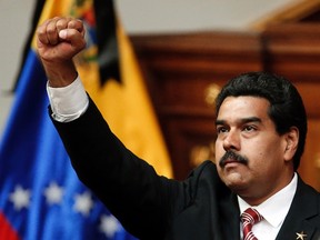 Acting Venezuelan President Nicolas Maduro raises his right fist during his swearing-in ceremony as caretaker president following the death of President Hugo Chavez in Caracas March 8, 2013. (Jorge Silva/Reuters)