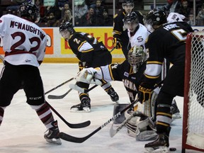 Tyler Hore (5) of the Sarnia Sting kicks the puck into his own net while goalie J.P. Anderson and Cody mcNaughton (22) of the Guelph Storm look on Sunday, March 10, 2013 at the RBC Centre in Sarnia, Ont. PAUL OWEN/THE OBSERVER/QMI AGENCY
