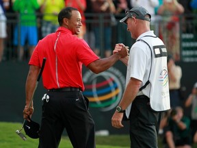 Tiger Woods celebrates with his caddie Joe LaCava after sinking his final putt on the 18th green to win the 2013 WGC-Cadillac Championship PGA golf tournament in Doral, Florida March 10, 2013. (REUTERS)