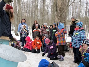 Outdoor education student Josh Wilson speaks to a Grade 2 class from St. Marguerite Bourgeoys school in the sugar bush at the Little Cataraqui Creek conservation area. (Patrick Kennedy The Whig-Standard)