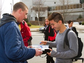 Chris Los of London gets an autograph from U.S. men?s champion Max Aaron as the American arrives on a bus at the London Hilton with other competitors from Toronto on Sunday for the world figure skating championships at Budweiser Gardens this week. (MIKE HENSEN, The London Free Press)