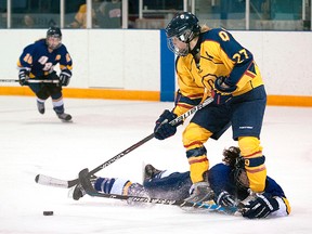 Queen's Golden Gaels forward Brittany McHaffie takes the puck away from a sliding UBC Thurnderbird during their fifth place game at the CIS  women's Hockey Championships at the University of Toronto on
Sunday. UBC won 2-1. (ANGELINA CAMPIGOTTO For The Whig-Standard)