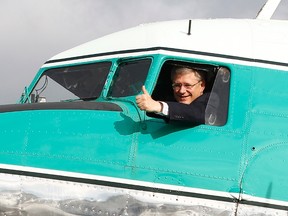 Prime Minister Stephen Harper gestures from the cockpit of a Douglas DC-3 aircraft in Yellowknife, Northwest Territories in this August 25, 2011 file photo. (REUTERS/Chris Wattie)