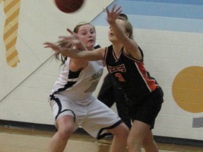 Effectively blocked by Jasmine Little, Whitecourt’s St. Joseph School Saint, Mayerthorpe’s Tiger Sydney Klassen passes the ball in the senior basketball provincial final which was hosted at Mayerthorpe Junior Senior High School on Monday, March 4. The Tigers won, earning the gold.