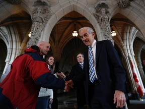 Former U.S. congressman Ron Paul, right, shakes hands on Parliament Hill in Ottawa March 7, 2013. (REUTERS/Chris Wattie)