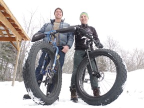 Greg Prodan and Andre Riopel straddle the 'fat bikes' they will ride next week as they travel the ice road between Moosonee and Attawapiskat.