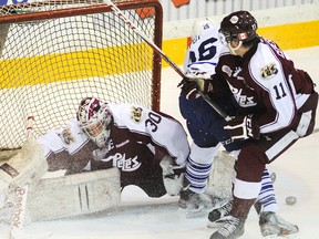 Peterborough Petes goalie Andrew D’Agostini looks for the loose puck next to Mississauga Steelheads’ Brett Foy as the Petes’ Peter Ceresnak moves in during first-period OHL action on Tuesday night at the Memorial Centre in Peterborough. The Petes won 3-2 in a shootout. (Clifford Skarstedt/QMI Agency)