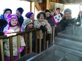 Angela McAneney, an education assistant with the Cataraqui Region Conservation Authority, demonstrates the evaporator to a group of school children at the Little Cataraqui Creek Conservation Area sugar bush.     Rob Mooy-Kingston This Week