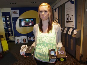 Sales associate Brittany Toth of Bell Woodstock shows off several different cellular phone models that were stolen early Wednesday morning. Thieves made off with $30,000 in state-of-the-art equipment from the Dundas Street store. HEATHER RIVERS/WOODSTOCK SENTINEL-REVIEW