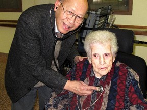 Alice London got a house call and a present from her family physician Dr. Francis Ng who stopped by her 100th birthday party, held at the Copper Terrace in Chatham Wednesday. Dr. Ng, who checked London's heart for fun, said she is one of the healthiest people he knows. ELLWOOD SHREVE/ THE CHATHAM DAILY NEWS/ QMI AGENCY